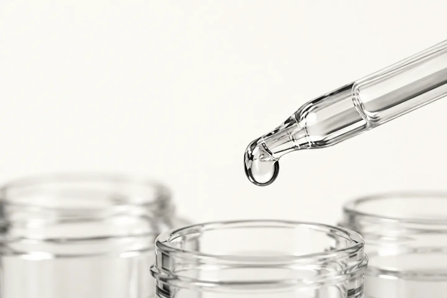 Skleněná pipeta nad čistými kelímky v ateliéru